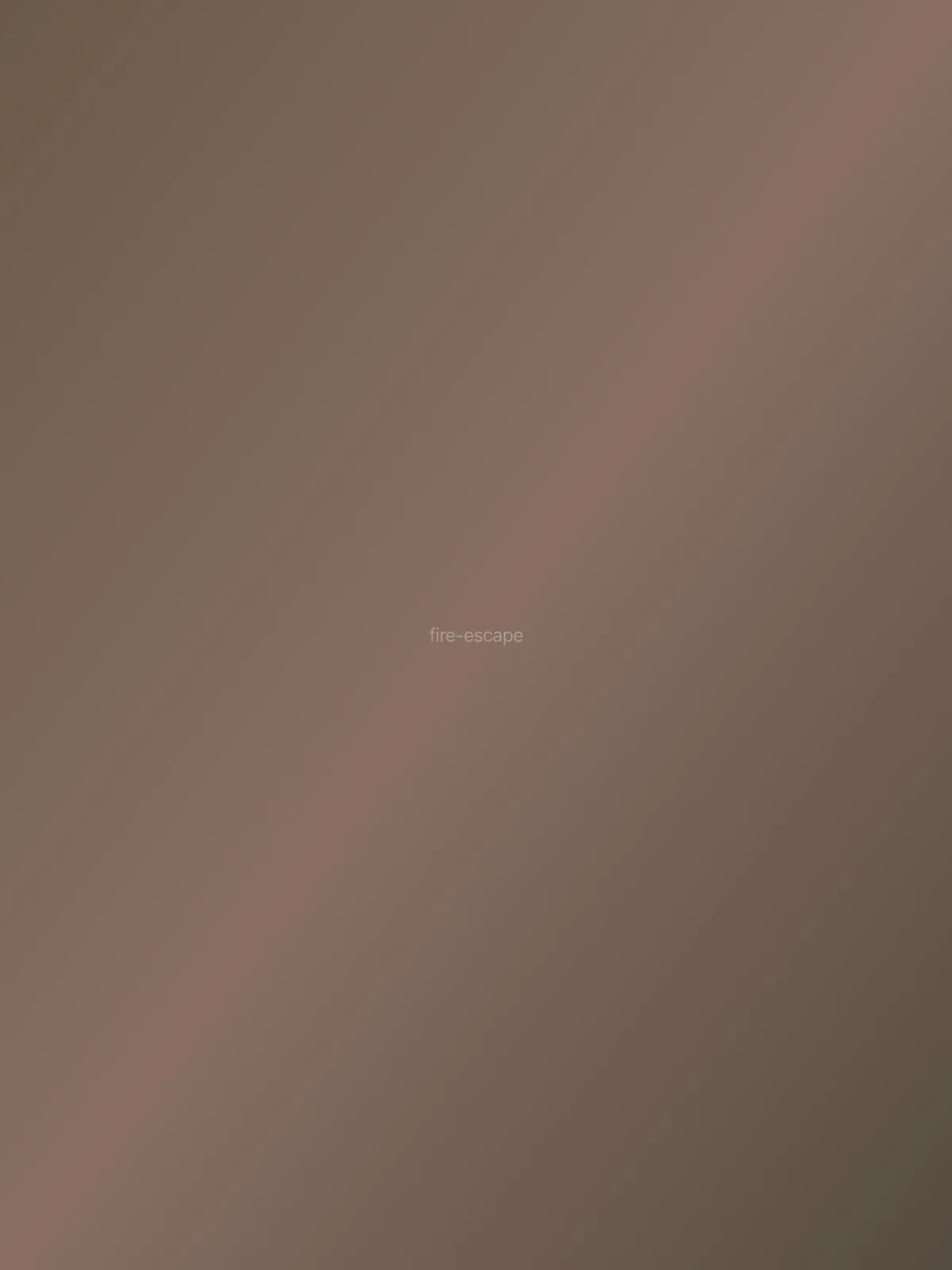 Fire escape casting geometric shadows on brick wall